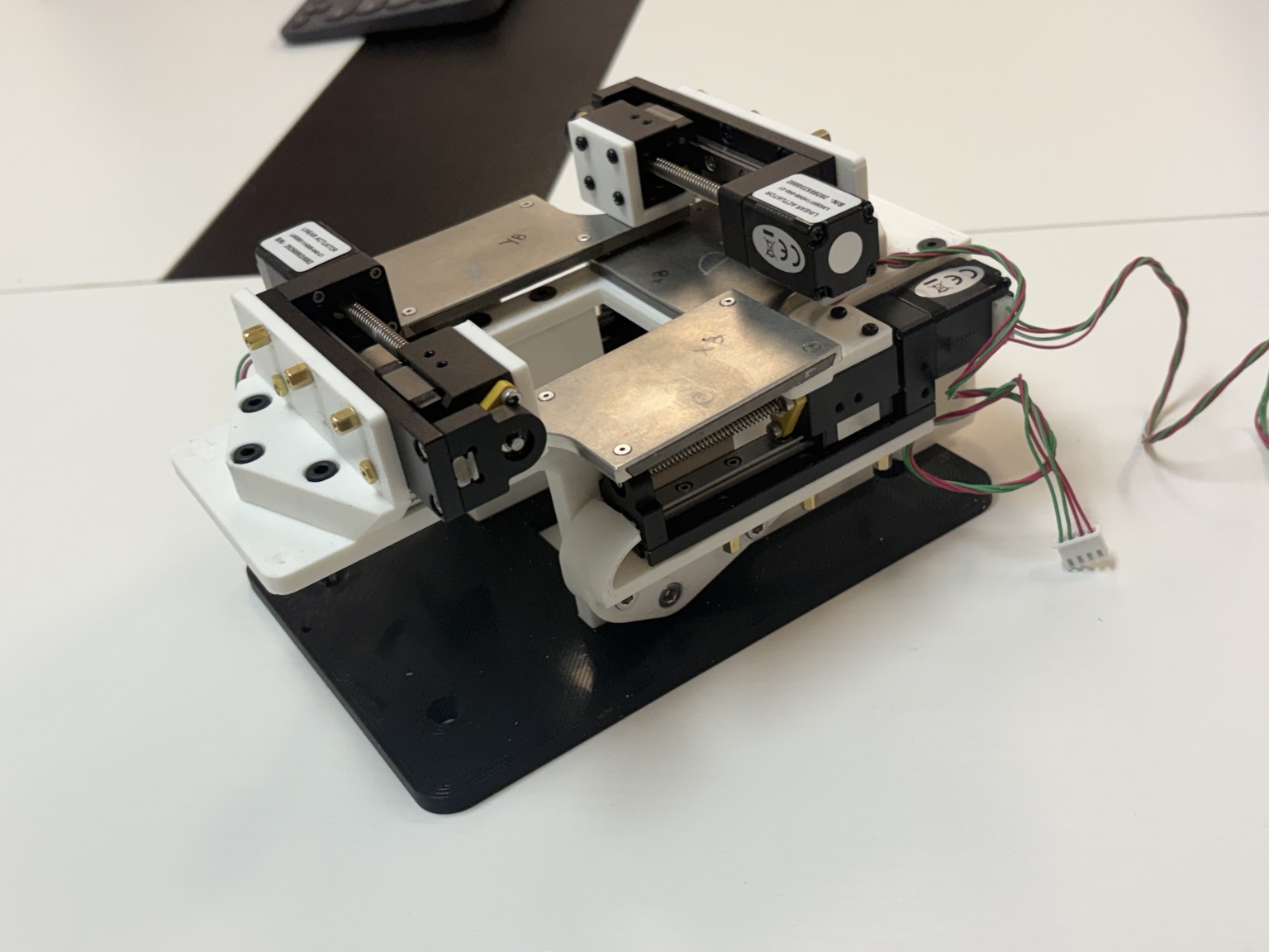 Physical precision collimator prototype with linear motion hardware, custom mounts, and 3D-printed structure.